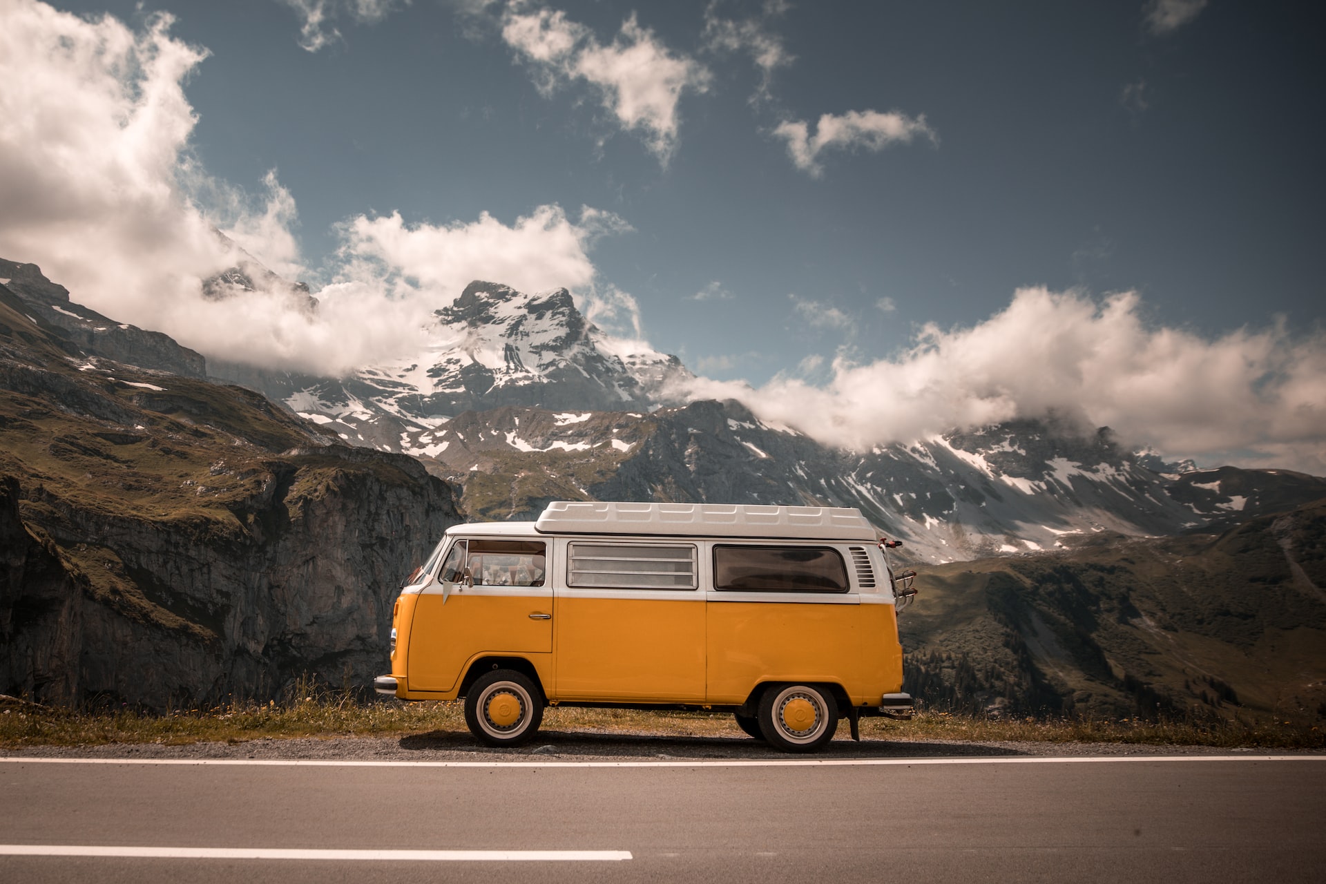 Alter VW-Bus parkt am Strassenrand in einem Berg-Panorama
