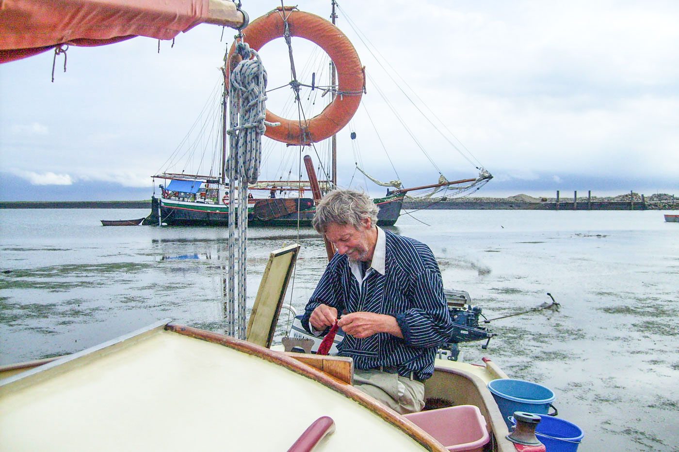 Bernd Martens flickt etwas auf dem Segelschiff.