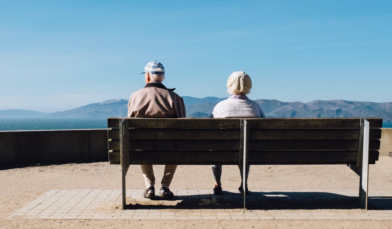 Älteres Paar auf einer Bank am Meer.